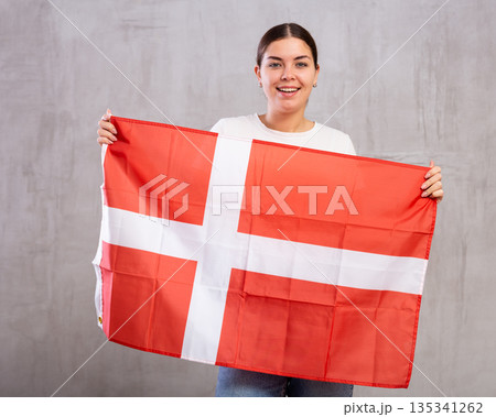 Pretty girl holding the Danish flag in her hands Pretty girl holding the Danish flag in her hands 135341262