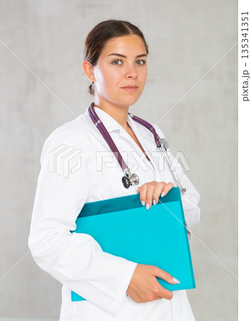 Young woman posing in medical uniform with folder 135341351