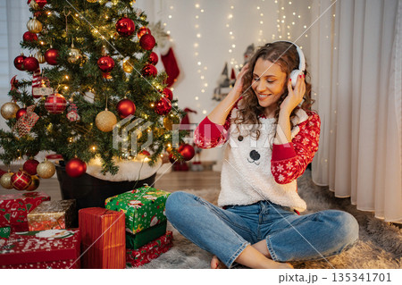 Young adult woman listening to music during Christmas holiday 135341701