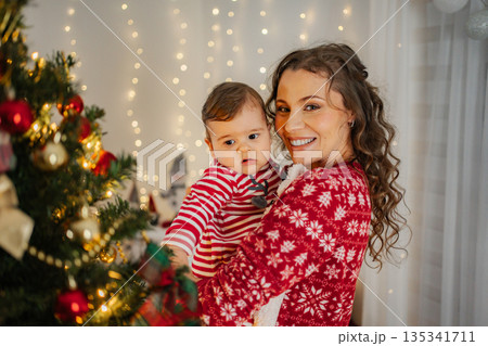 Mother holding baby celebrating Christmas at home 135341711