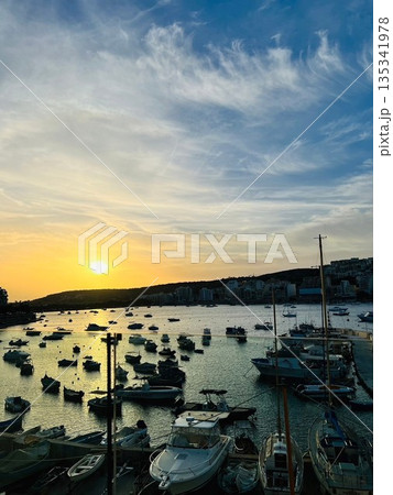 マルタの港に沈む夕日と停泊するボートが並ぶサンセット風景 マルタの港に沈む夕日と停泊するボートが並ぶサンセット風景 135341978