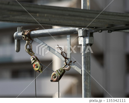 工事現場の足場に付けられた滑車 135342111