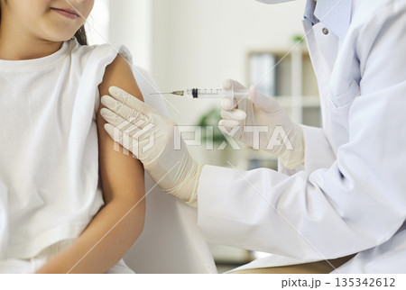 Vaccination of child in pediatric clinic, doctors hands give vaccine injection Vaccination of child in pediatric clinic, doctors hands give vaccine injection 135342612