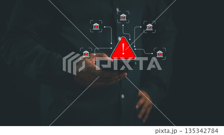 Person holding smartphone with warning alert and bank icon, symbolizing online banking fraud, financial scam, cybersecurity risk, and digital safety awareness in mobile transaction and fintech system. Person holding smartphone with warning alert and bank icon, symbolizing online banking fraud, financial scam, cybersecurity risk, and digital safety awareness in mobile transaction and fintech system. 135342784
