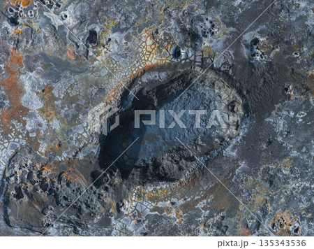 Aerial view of a geothermal area in Iceland with a bubbling mud pot, volcanic rock, and orange and yellow mineral deposits in a textured landscape. Aerial view of a geothermal area in Iceland with a bubbling mud pot, volcanic rock, and orange and yellow mineral deposits in a textured landscape. 135343536