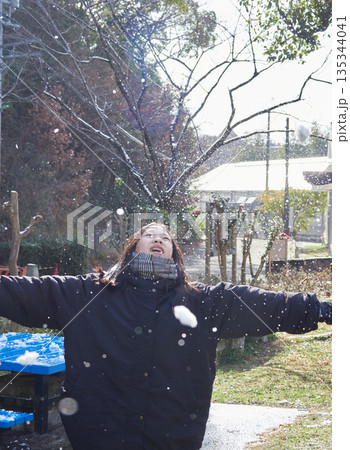 冬の朝の積雪の公園で楽しく雪合戦で遊んでいる女の子の子供の様子 冬の朝の積雪の公園で楽しく雪合戦で遊んでいる女の子の子供の様子 135344041