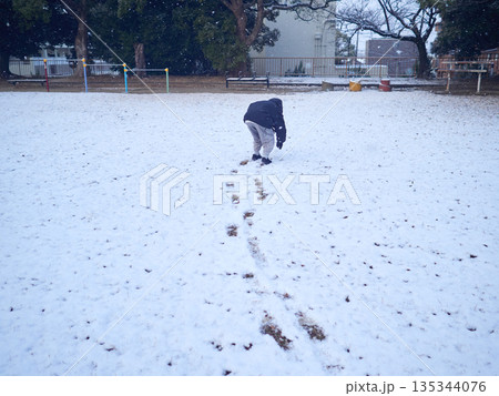 冬の積雪の公園で雪遊びしている一人の子供の様子	 135344076