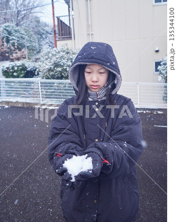 冬の朝の住宅地の駐車場で雪遊びしている女の子の様子 冬の朝の住宅地の駐車場で雪遊びしている女の子の様子 135344100