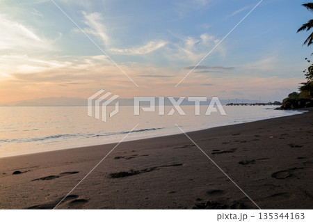 Serene Beach at Dusk with Calm Water and Soft Clouds casting Natural Light, perfect for coastal relaxation and travel concepts Serene Beach at Dusk with Calm Water and Soft Clouds casting Natural Light, perfect for coastal relaxation and travel concepts 135344163