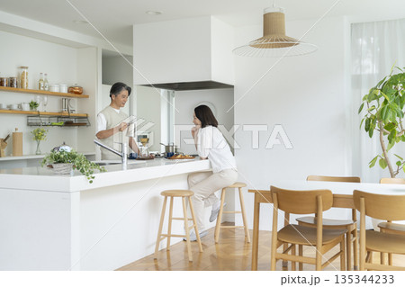 ダイニングキッチンでコーヒーを楽しむ50代の夫婦 ダイニングキッチンでコーヒーを楽しむ50代の夫婦 135344233