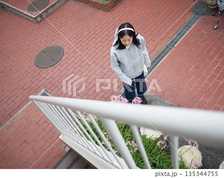 休日の冬の朝の住宅の階段にいる女子中学生の様子 135344755