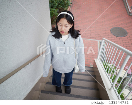 休日の冬の朝の住宅の階段にいる女子中学生の様子 休日の冬の朝の住宅の階段にいる女子中学生の様子 135344781