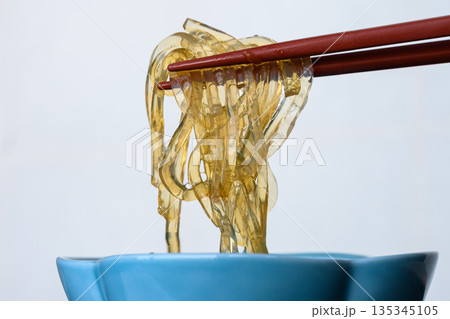 箸で持ち上げた透明なところてん 伊豆名物の天草グルメ 箸で持ち上げた透明なところてん 伊豆名物の天草グルメ 135345105