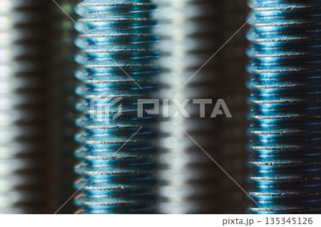Detailed view of metallic screw threads with blue lighting and shallow depth of field Detailed view of metallic screw threads with blue lighting and shallow depth of field 135345126