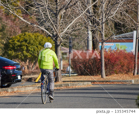 冬の朝の公園で自転車を乗って運動する中年男性の姿 冬の朝の公園で自転車を乗って運動する中年男性の姿 135345744