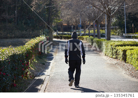 冬の朝の街の公園で散歩しているシニア男性の姿 冬の朝の街の公園で散歩しているシニア男性の姿 135345761
