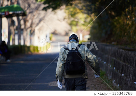冬の朝の街の公園で散歩しているシニア男性の姿 冬の朝の街の公園で散歩しているシニア男性の姿 135345769