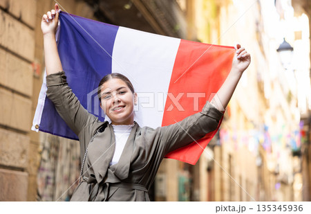 Young smiling woman holding France flag Young smiling woman holding France flag 135345936