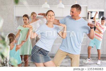 Home holiday - large family dancing together in living room at home 135346063