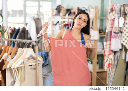 Young woman choosing jumpsuit in clothing store Young woman choosing jumpsuit in clothing store 135346142