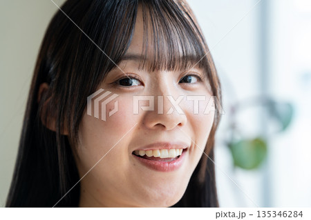 明るい笑顔でこちらを見つめる女性の顔アップ 135346284