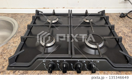 Contemporary kitchen appliance featuring four burners and glossy finish 135346649