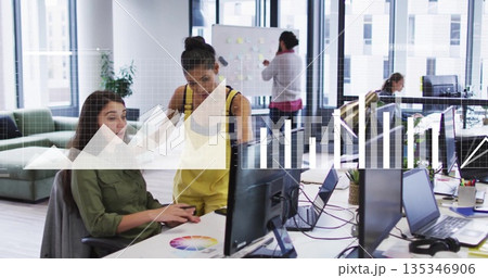 Collaborating two coworkers typing and pointing at screen in shared office, with color wheel 135346906