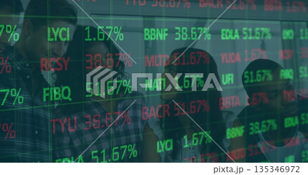Standing team of four reviewing market data on glass partition in office, projected stock symbols 135346972
