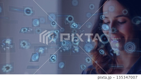 Data analyst analyzing holographic display panels with world map in modern office, copy space 135347007