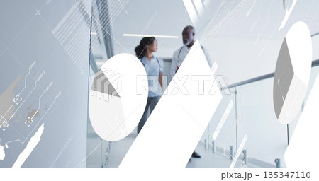 Walking professionals discussing data in hallway, with glass railing, lights, charts and pie graphs Walking professionals discussing data in hallway, with glass railing, lights, charts and pie graphs 135347110
