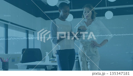 Discussing mid adult women analyzing smartphone screen in modern office, with digital data overlays Discussing mid adult women analyzing smartphone screen in modern office, with digital data overlays 135347181
