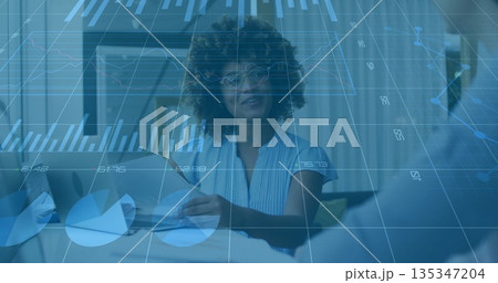 Discussing executive holding charts, speaking to colleague at office desk with monitor overlay Discussing executive holding charts, speaking to colleague at office desk with monitor overlay 135347204