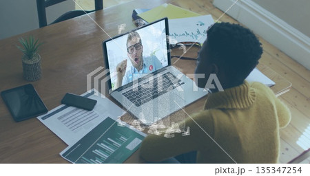 Working woman wearing yellow sweater using laptop at home office, with smartphone, copy space 135347254