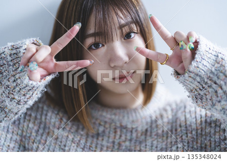 ピースサインをする女性 135348024