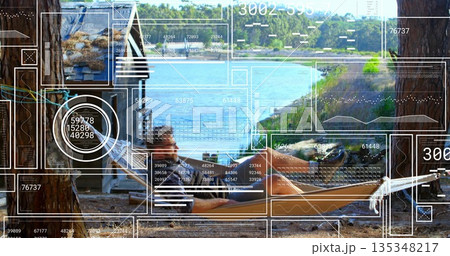 Reclining man in rope hammock under pine trees at wooden lake cabin, with HUD overlay 135348217
