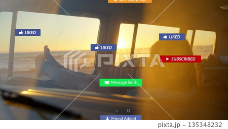 Reclining barefoot woman gazing toward ocean horizon inside beach van, with social media overlays 135348232