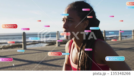 Woman running in red sports bra along seaside path by railing, with digital overlays, copy space 135348266