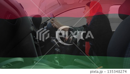 Gripping steering wheel woman wearing red hijab driving urban car cabin with seat belt, copy space 135348274