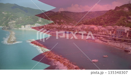 Capturing curved beach lining bay at seaside town, with loungers and umbrellas near breakwaters 135348307