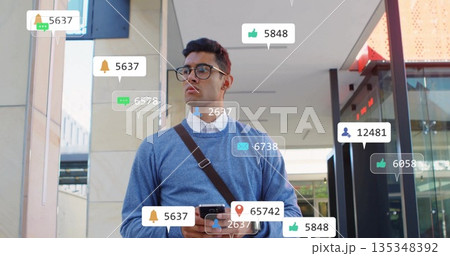 Checking Hispanic man holding smartphone, viewing notification icons at office entrance, with bag Checking Hispanic man holding smartphone, viewing notification icons at office entrance, with bag 135348392