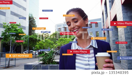 Smiling woman wearing blazer holding coffee walking in city plaza with digital overlays, copy space 135348395