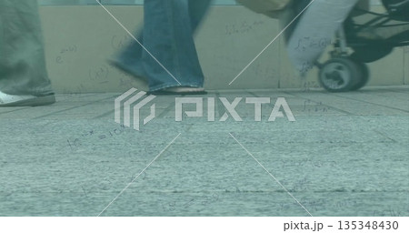 Walking adult in jeans on tiled pavement next to stone barrier with stroller wheel, math formulas 135348430