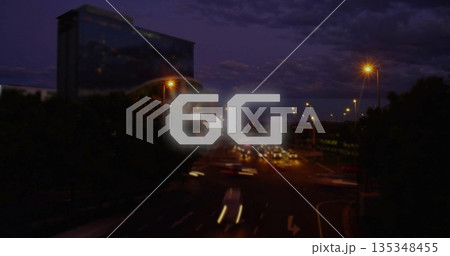 Floating 6G digital text graphic hovering over urban highway at night, with moving cars and lamps 135348455