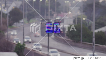 Glitching digital 5G overlay sign hovering above multi-lane freeway, showing wireless connectivity 135348456