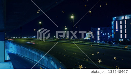 Stretching highway curving left at night by streetlights, with barrier, light trails, golden stars Stretching highway curving left at night by streetlights, with barrier, light trails, golden stars 135348467