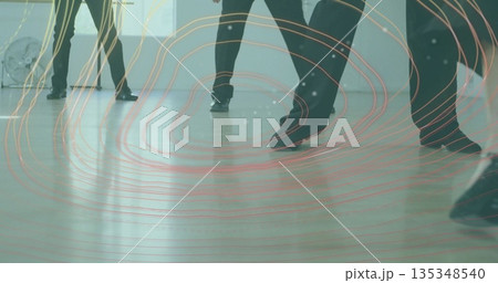 Practicing dancers in black dance shoes coordinating footwork in studio, with fan and digital lines 135348540