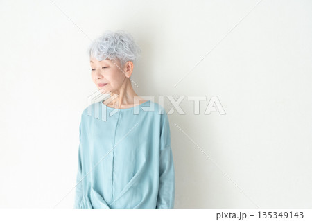 壁の前に立つシニア女性 135349143