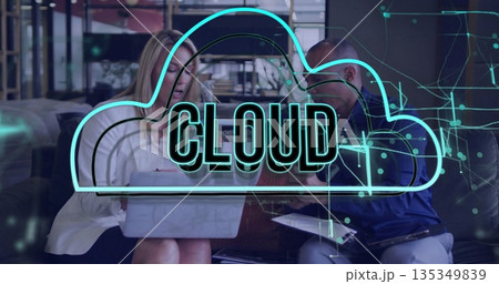 Collaborating colleagues sitting on couch using laptop, tablet in office lounge, with cloud graphic 135349839