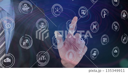 Businessman wearing suit and tie interacting with touch interface in workspace and floating icons 135349911