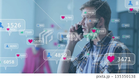 Holding smartphone to ear man in plaid shirt speaking in showroom, with mask and notification icons Holding smartphone to ear man in plaid shirt speaking in showroom, with mask and notification icons 135350138